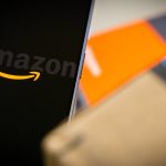 Amazon-logo-on-phone-next-to-boxes-stock-photo-12