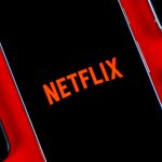 Netflix-logo-on-smartphone-next-to-other-devices-stock-photo-2