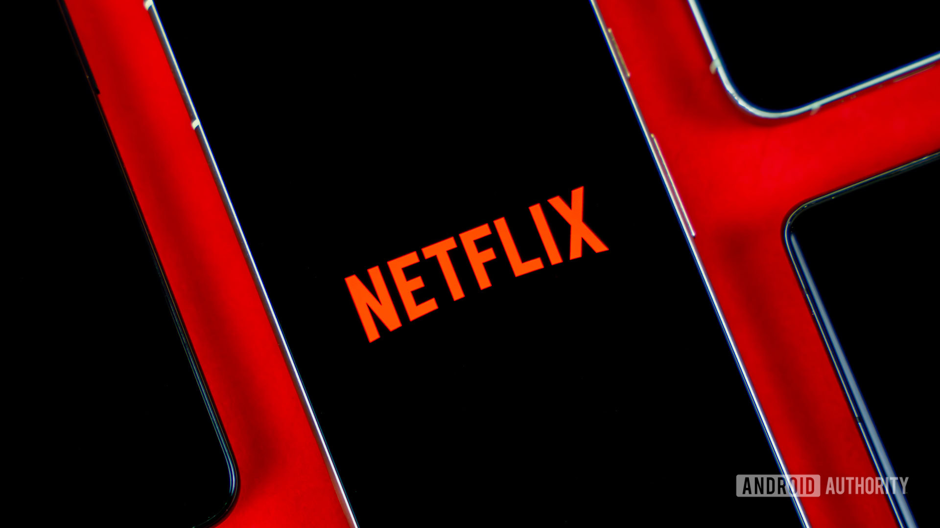 Netflix-logo-on-smartphone-next-to-other-devices-stock-photo-2